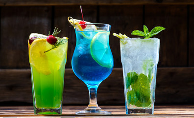 green fairy cocktails with lemon and absinthe, a blue lagoon and mojito in a bar