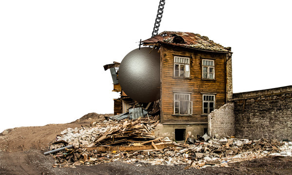 An old vintage wooden house being demolished with a wrecing ball isolated on white