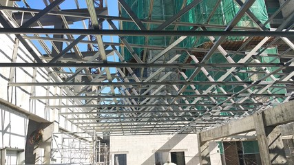 Obraz premium KUALA LUMPUR, MALAYSIA -JUNE 16, 2019: Lightweight roof trusses under construction at the construction site. Installed properly by workers to received the roof covering system. 