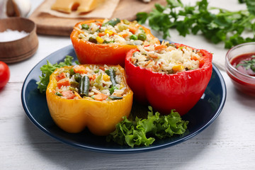 Tasty stuffed bell peppers served on white wooden table