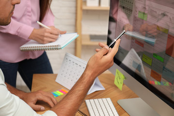 Colleagues working with calendar app on computer in office, closeup