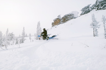 Rider with snowbike on snow covered mountain slop. Sunny fog, outdoor activity in winter day