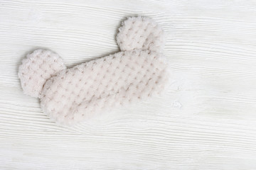 Eye mask for sleeping made of fluffy faux fur on white background. Top view. Flat lay.