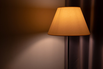 floor lamp stands near curtains