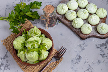 Boiled khinkali made of dough with spinach. Garnished with Red Chilli, Dill and Parsley. On a light...