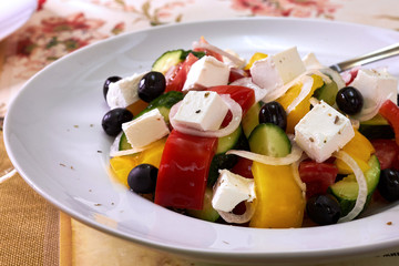Greek salad with feta cheese, organic kalamata olives, juicy tomatoes, red pepper, red onion, cucumber and lettuce. Concept for healthy nutrition. Tasty and healthy vegetarian meal. Close up.