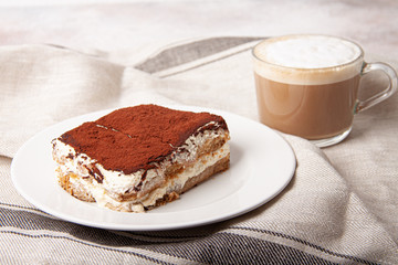 Tasty piece of tiramisu with cup of coffee. Homemade tiramisu with cappuccino.
