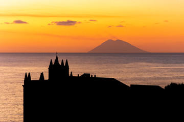Obraz premium Tropea, Calabria, Italy: sunset with view of the Stromboli volcano and the Church of Santa Maria dell'Isola, the medieval shrine of the city built on the top of a small islet in the Tyrrhenian Sea