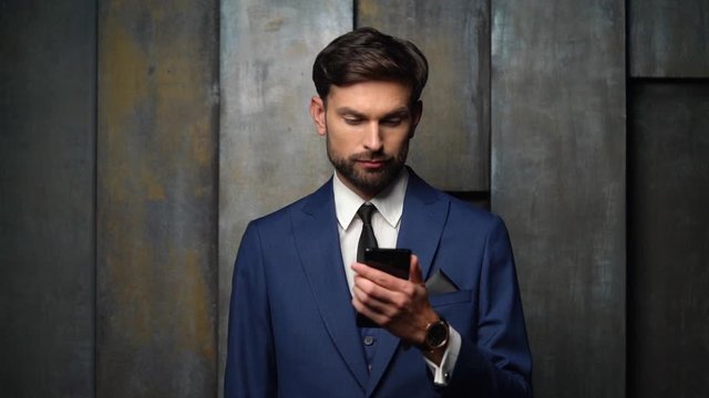 full hd video of young handsome stylish businessman using smartphone - 4x slow motion