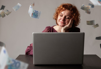 Red-haired woman with laptop. Red-haired woman and falling Euro banknotes.