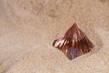 Pink crystal glass pyramid on sea shore sand