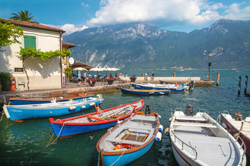 Fototapeta na wymiar LIMONE SUL GARDA, ITALY - JUNE 13, 2019: The little harbor under the alps rocks on the Lago di Garda lake.