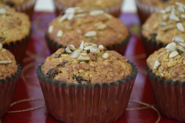 Healthy muffin with sunflower seeds oatmeal and raisins on red plate