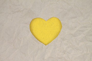 Yellow felt heart on craft paper. Crumpled paper texture. Valentine's day stock photo for web,...
