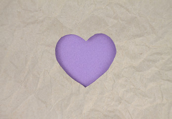 Fototapeta premium Violet felt heart on craft paper. Crumpled paper texture. Valentine's day stock photo for web, print and wallpaper.With empty space for text.