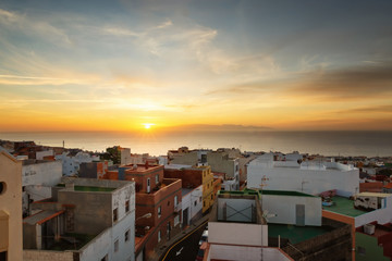 Dawn on Tenerife Island in a small town, colorful houses, sun rising over Gran Canaria