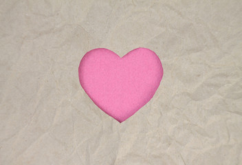 Pink felt heart on craft paper. Crumpled paper texture. Valentine's day stock photo for web, print and wallpaper.With empty space for text.