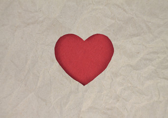 Fototapeta premium Red felt heart on craft paper. Crumpled paper texture. Valentine's day stock photo for web, print and wallpaper.With empty space for text.