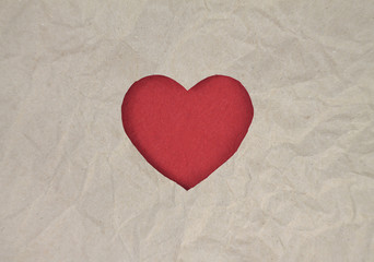 Red felt heart on craft paper. Crumpled paper texture. Valentine's day stock photo for web, print and wallpaper.With empty space for text.