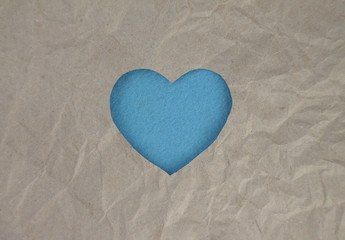 Blue felt heart on craft paper. Crumpled paper texture. Valentine's day stock photo for web, print and wallpaper.With empty space for text.
