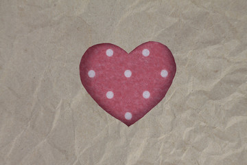 Felt heart with polka dot pattern on craft paper. Crumpled paper texture. Valentine's day stock photo for web, print and wallpaper. With empty space for text.