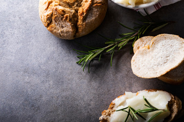 Crispy bread roll and sandwich with homemade lard on a dark stone countertop. 