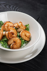 Fried shrimps with yogurt sauce and greens on plate