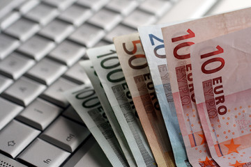 Euro banknotes on a silver keyboard