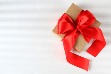 Wrapped vintage gift box with red ribbon bow on white background