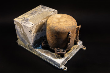 Damaged Aircraft flight data recorder on black background. Black Box with extensive fire damage after an accident or production testing of equipment