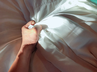 The man's hand pulled the white sheets, Hand mauled the white sheets on the bed, hands of a doctor...