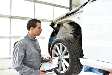 Fototapeta na wymiar service and inspection of a car in a workshop - mechanic inspects the technology of a vehicle for function and safety