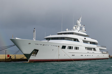 Fototapeta na wymiar White luxury super yacht moored in marina.