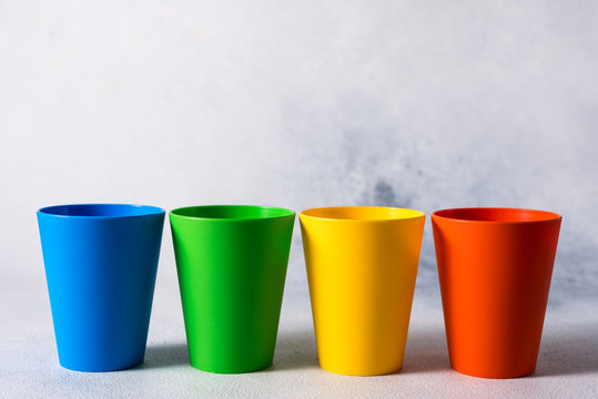 group color plastic cups on gray stone background plastic waste