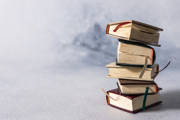 A stack of old little books. Shabby pages, damaged book covers.