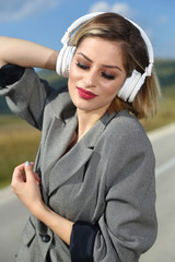 Woman with headphones on the road