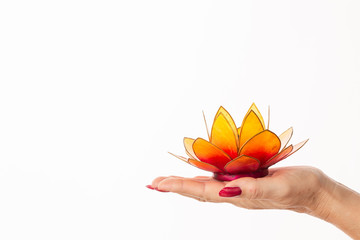 woman hand holding a lotus flower shaped candle holder isolated on white background