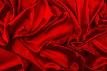 Red silk or satin luxury fabric texture can use as abstract background. Top view.