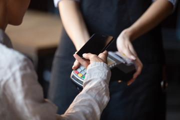 Woman customer pay with cellphone using contactless method