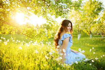 Girl at sunset in a flowering garden