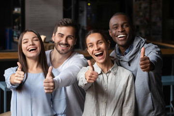Portrait of happy young people show thumbs up recommending service