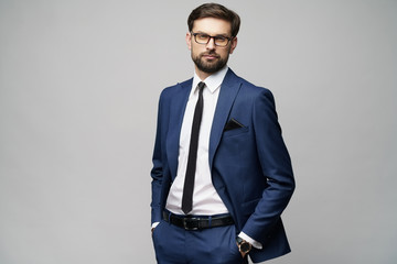 studio photo of young handsome stylish businessman wearing suit