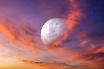 Moon in bright clouds of sunset sun . New moon .  The sky at night with stars. 