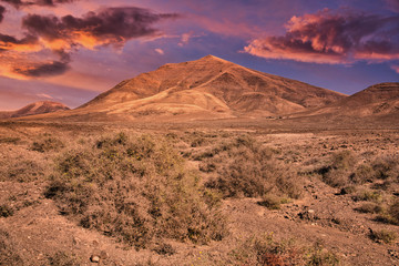 view to the volcanic mountain Hacha Grande near Papagayo beach in Lanzarote, Spain during sunset