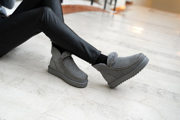 gray female stylish uggs with a stitching on legs indoors