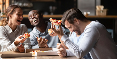 Happy multiracial friends enjoy tasty pizza from takeaway delivery