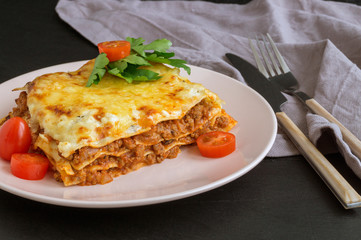 Meat lasagna on a wooden background.