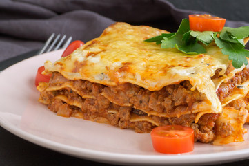 Meat lasagna on a wooden background.