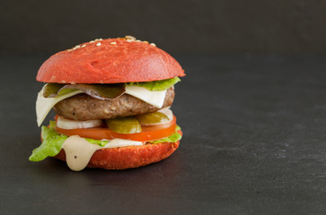 burgers with colored buns on a black background.