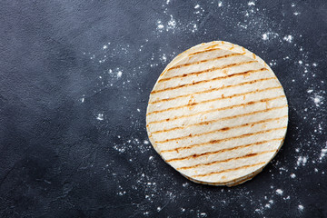 Grilled tortillas, flat breads on dark grey background. Copy space. Top view.